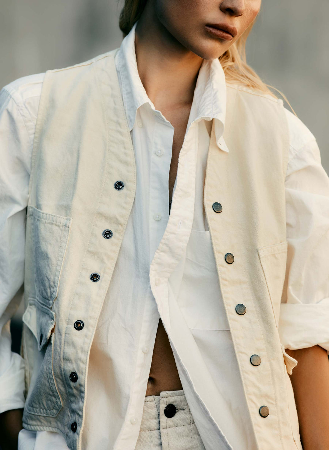 a woman wearing a white shirt and a white vest