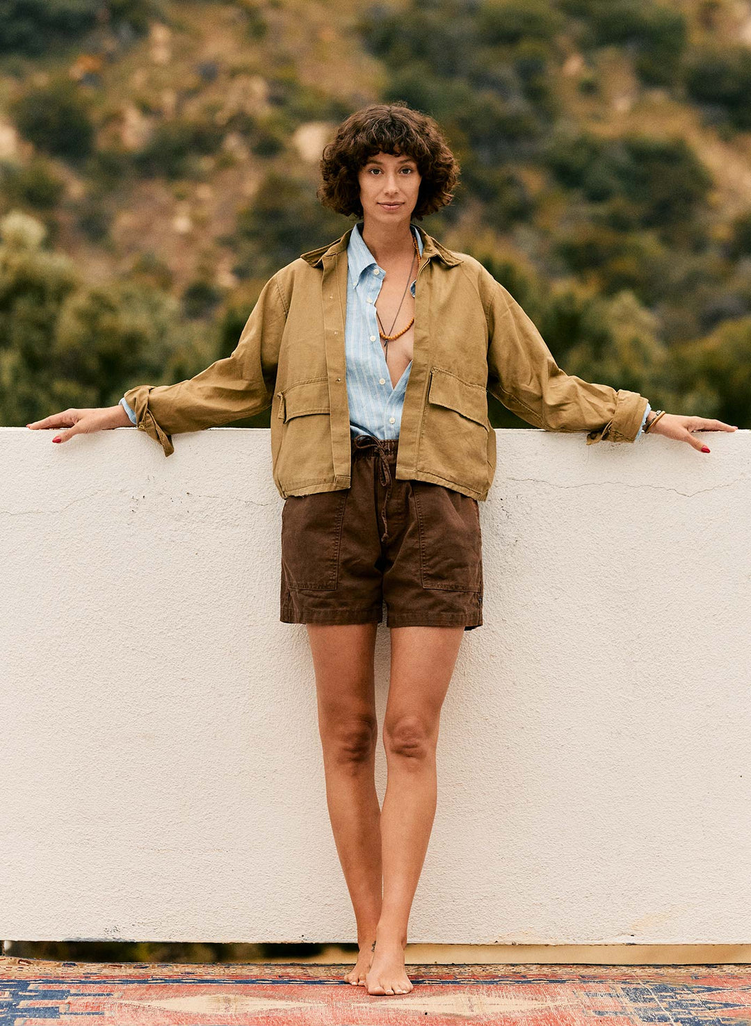 a woman leaning against a wall