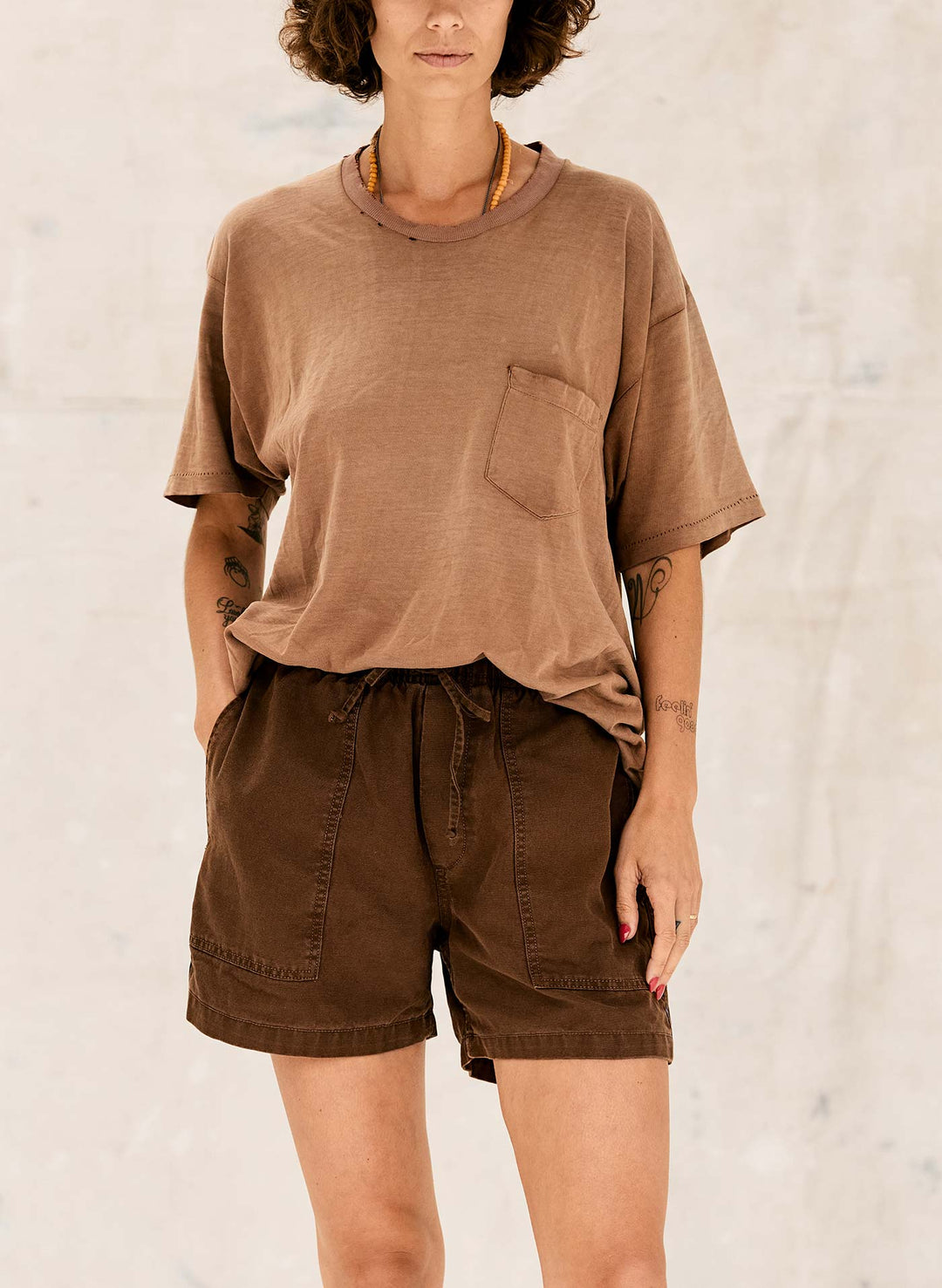 a woman wearing brown shorts and a brown shirt