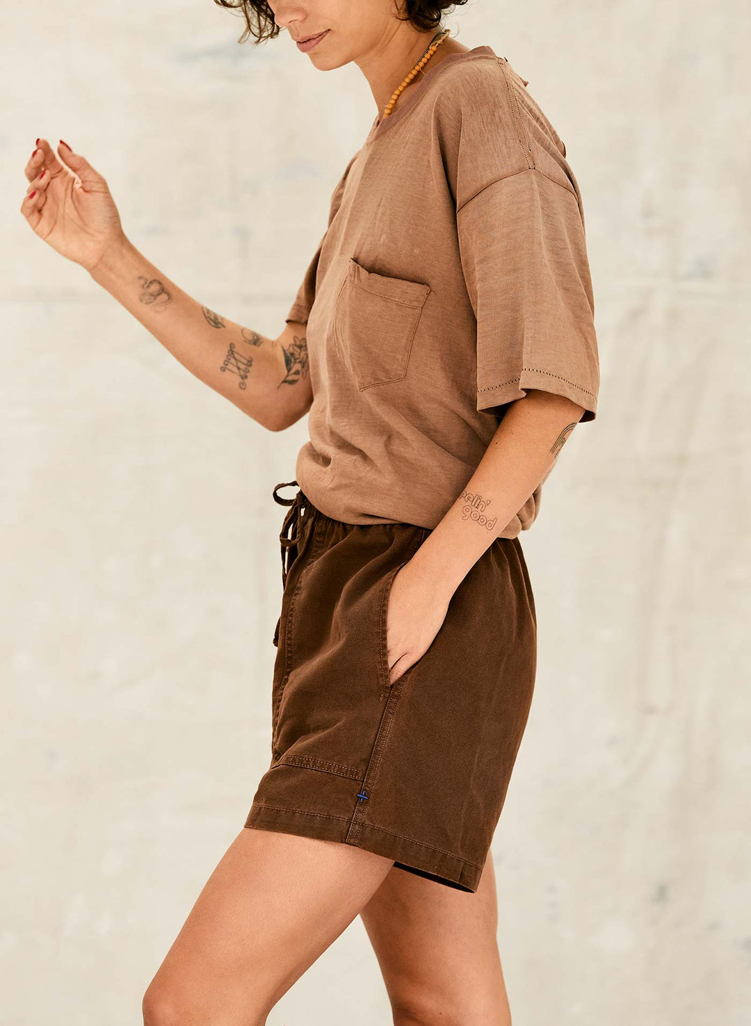 a woman wearing brown shorts and a brown shirt