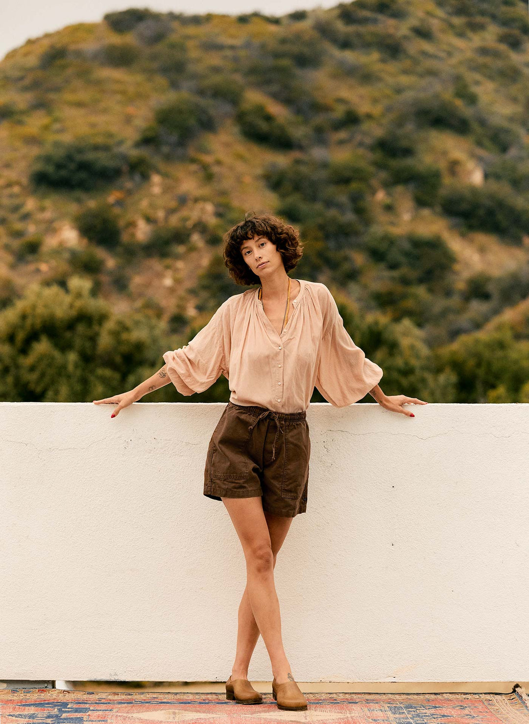 a woman leaning on a wall