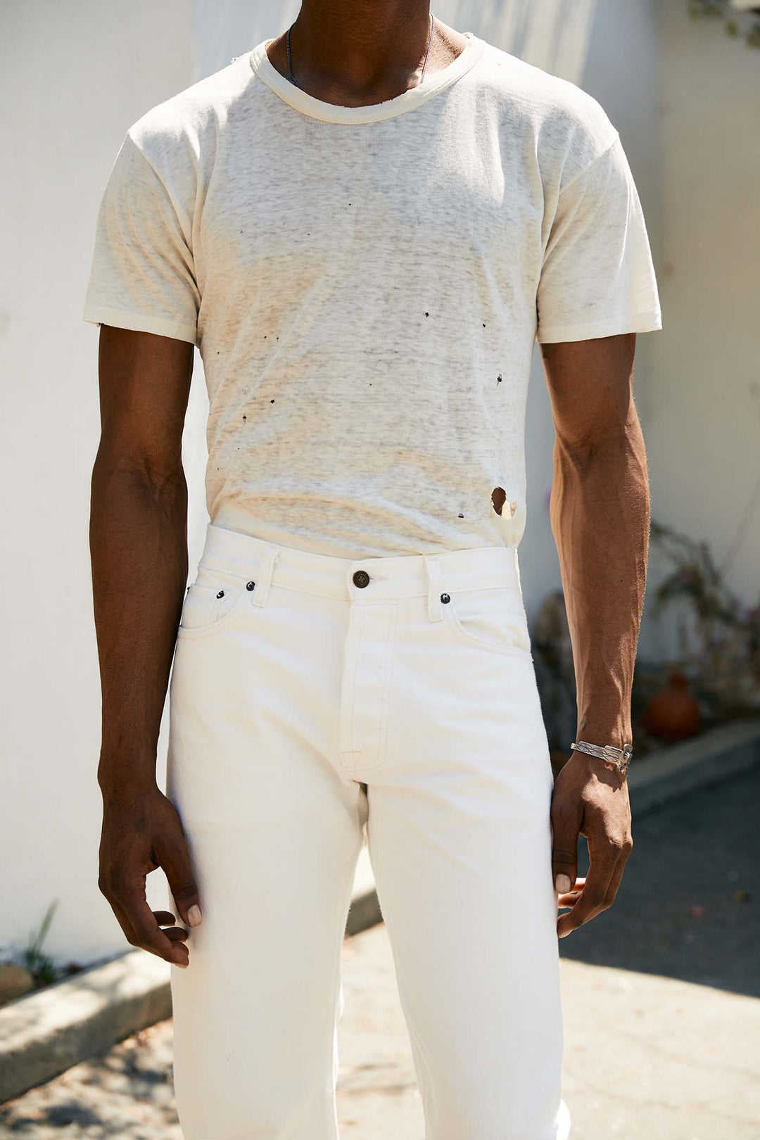 a man wearing white pants and a white t-shirt