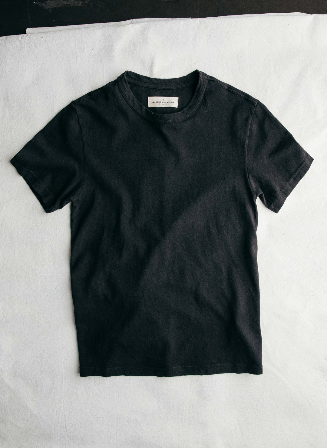 a black t-shirt on a white surface