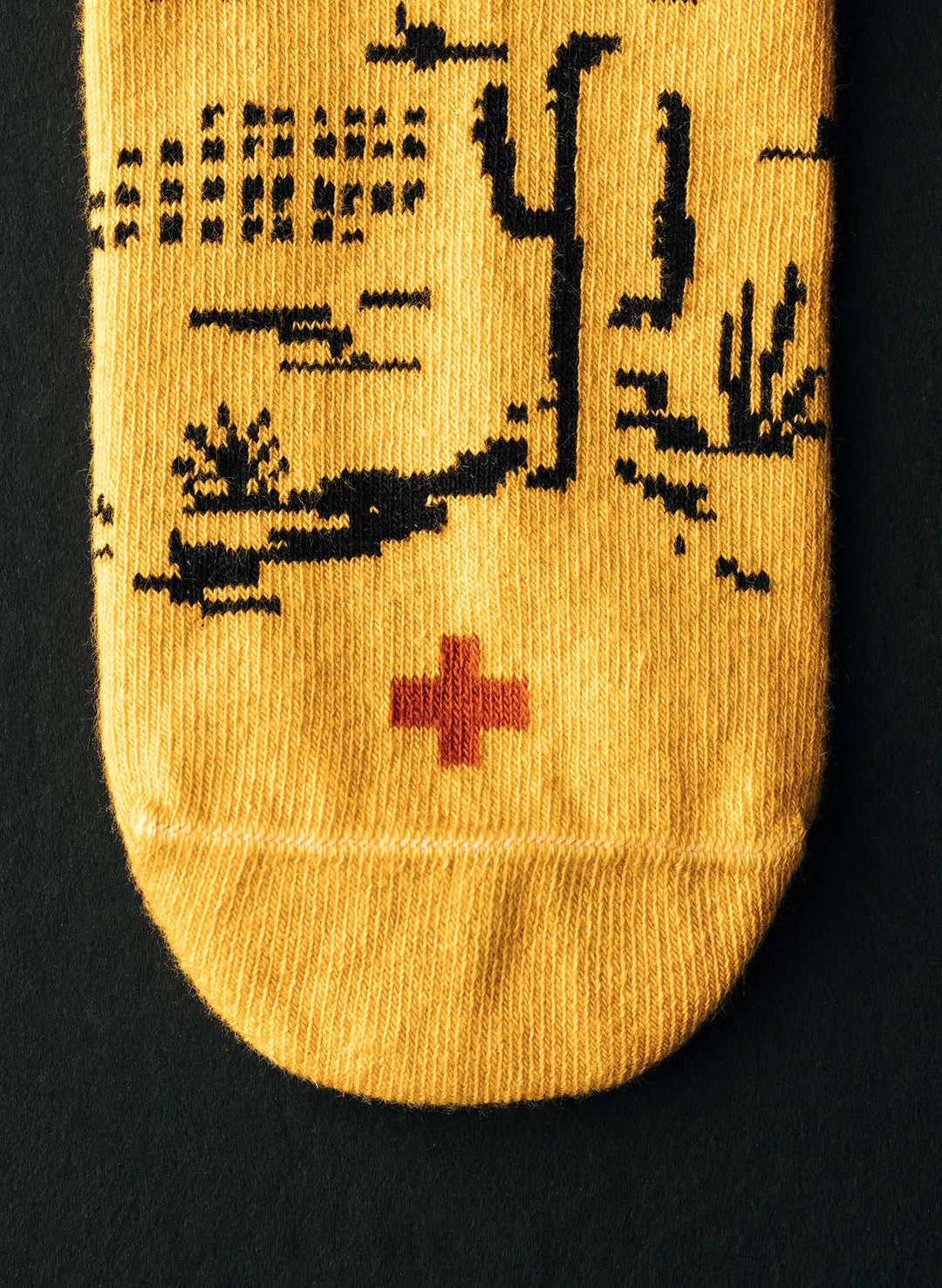 a yellow sock with a red cross on it