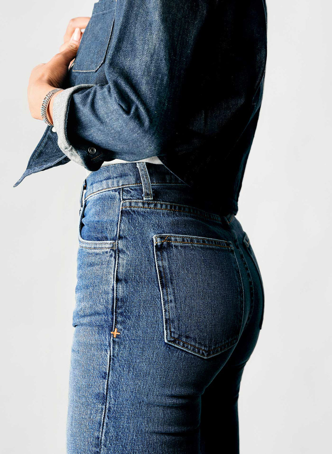 a woman in jeans with her hands crossed