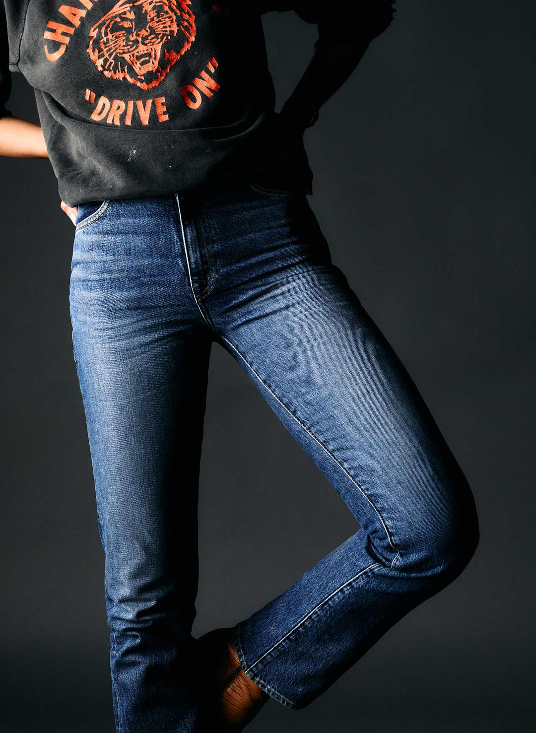 a person wearing blue jeans and black shoes
