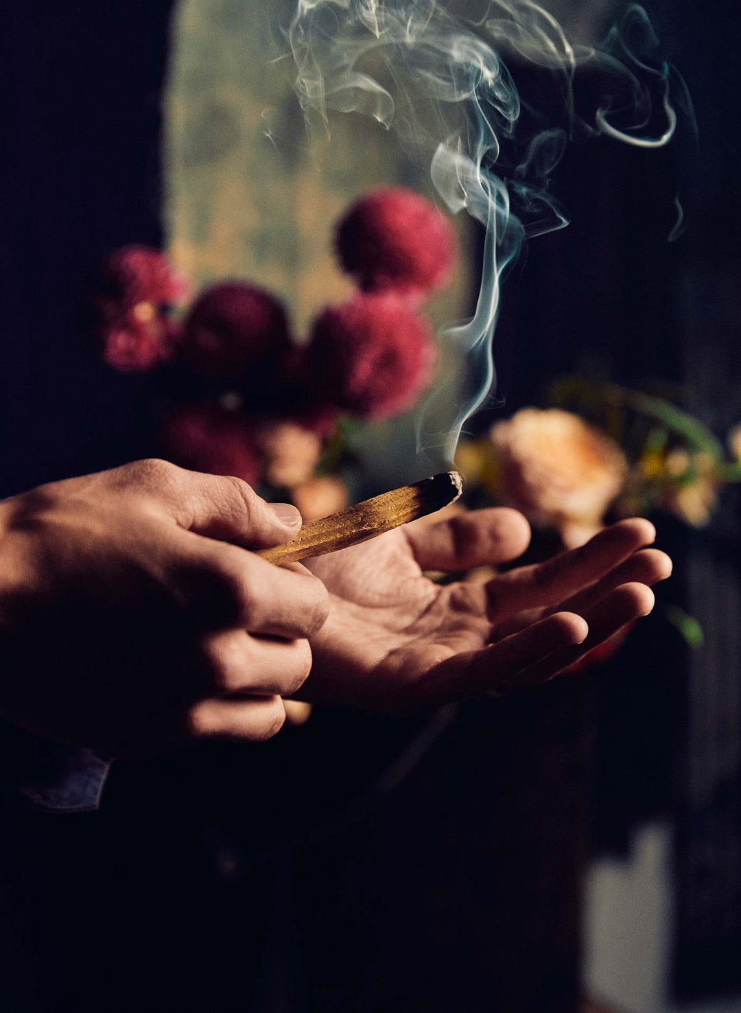 a person holding a stick with smoke coming out of their hands